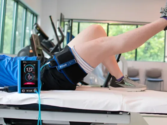 Patient using blood flow restriction cuffs during a supervised exercise at Dynamic Physical Therapy