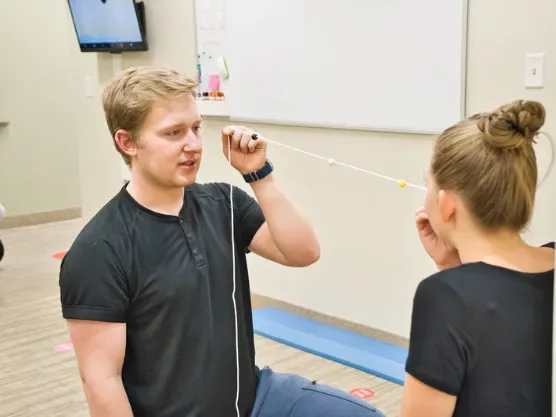Therapist guiding a patient through a vestibular tracking exercise at Dynamic Physical Therapy