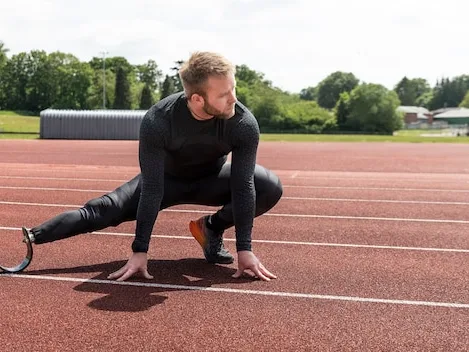 Athlete in a starting stretch on a track, training for sports performance